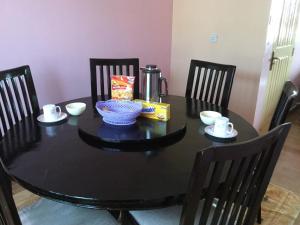 内罗毕朴穆兹卡公寓的餐桌,配有黑色的桌子和椅子