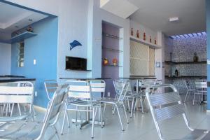 北茹阿泽鲁Pousada Planalto的一间设有白色椅子和蓝色墙壁的用餐室