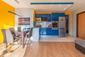 布达佩斯布达佩斯迷你风格公寓 - 你会爱上它！的厨房配有蓝色橱柜和桌椅