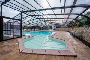 坎丕里亚麦利蒂玛Il Castagno Toscana的一个带玻璃天花板的室内游泳池