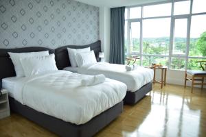 达叻府阿瓦达酒店的酒店客房设有两张床和大窗户。