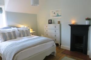切斯特30 Overleigh Road的卧室配有白色的床和壁炉