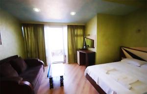 巴统Black Sea Star Batumi的客房设有床、沙发和窗户。