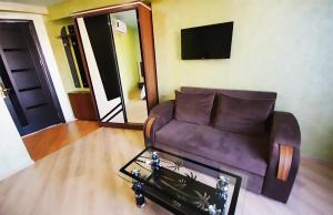巴统Black Sea Star Batumi的客厅配有棕色沙发和桌子