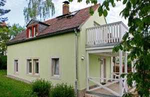 德累斯顿Kleines Häuschen - Ferien in Cossebaude的绿色和白色的房子设有阳台