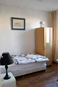 代尔夫宰尔Pension Delfzijl的一间卧室配有带灯具和橱柜的床