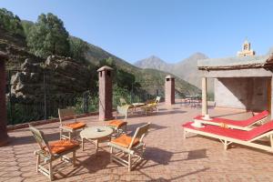 伊姆利尔Hiba Lodge的庭院配有桌椅,背景为山脉