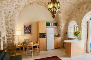 萨法德艺术区住宿加早餐旅馆的厨房以及带冰箱和桌子的用餐室。