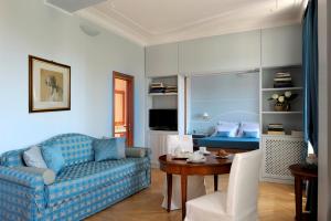 罗马德亚套房罗马酒店的客厅配有蓝色的沙发和桌子