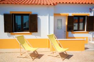 阿尔布费拉Vila - Mar - Private outdoor Jacuzzi - wifi & airco - by bedzy的两把黄色椅子坐在房子外面