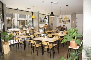 布宜诺斯艾利斯Épico Recoleta Hotel的餐厅设有木桌、椅子和盆栽植物