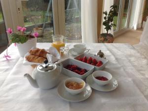 埃文河畔斯特拉特福莎士比亚景观酒店的一张桌子,茶具里装有水果和羊角面包
