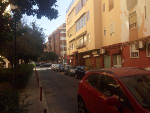 塞维利亚Apartment Triana to Sevilla的停在大楼旁的街道上的红色汽车