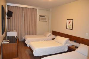 尼泰罗伊尼泰罗伊广场酒店的酒店客房设有三张床和电视。