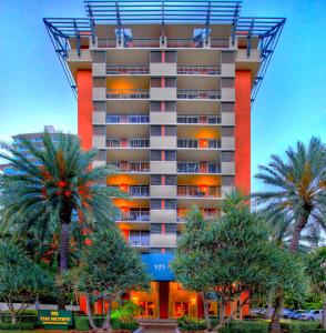 迈阿密慕缇旎豪华套房酒店的一座高大的建筑,前面有棕榈树