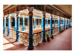 KānādukāttānChettinadu Mansion – An Authentic Heritage Palace的建筑物阳台上的一排蓝色柱子