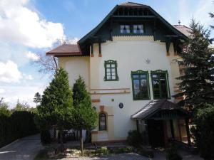 尼特拉扎莫克格洛法酒店的白色的房子,有黑色的屋顶和绿色的窗户