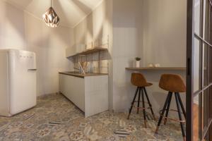卡利亚里Suite Cagliari -101-的厨房配有冰箱和2个吧台凳