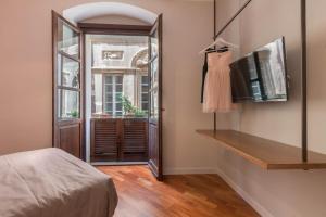 卡利亚里Suite Cagliari -101-的客房设有床、电视和窗户。