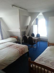 登博斯All-In Hotel的带三张床和椅子的房间以及窗户