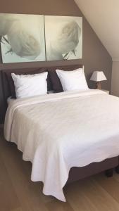 东代恩凯尔克B&B Soluna的一张配有白色床单和枕头的大床