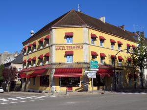 隆勒索涅Hôtel Terminus - Pizzeria Pizz'a gogo - salle de sport - face à la gare的街道拐角处的黄色建筑