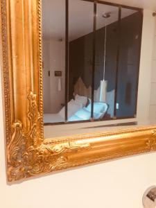 维泰勒维泰勒萨匹尼尔住宿加早餐旅馆的墙上的金框镜子,带床