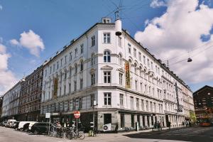 哥本哈根哥本哈根城市之家梅宁阁酒店的街道拐角处的白色大建筑