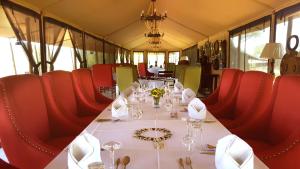 塞伦盖蒂国家公园Ole Serai Luxury Camp的一张桌子,火车上摆放着红色的椅子和一张白色的桌子