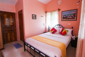 帕罗林Hilias Retreat的一间卧室配有一张带橙色墙壁和窗户的床