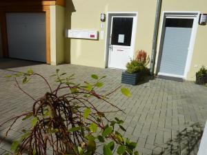 耶拿City Apartment Jena的一座房子,前面有一座车库和一座植物