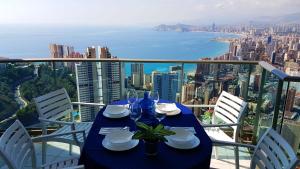 贝尼多姆Highrise apartment with private terrace & sea views - 34th floor的一张带椅子的蓝色桌子,享有海景