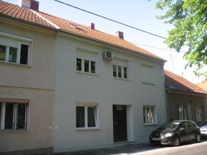 萨格勒布Jazzy Apartment Zagreb的前面有一辆汽车停放的白色房子