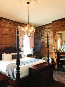 新奥尔良Lafitte Hotel & Bar的一间卧室配有一张大床和一个吊灯。