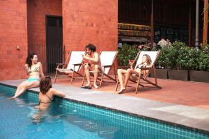 里约热内卢25号别墅旅舍的一群坐在游泳池边椅子上的女人