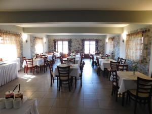 果拉阿克鲁提酒店的用餐室设有桌椅和窗户。