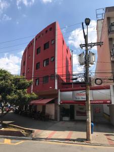 南圣卡埃塔诺HOTEL FLOR DO AMAZONAS (ADULTS ONLY)的街道边的红色建筑