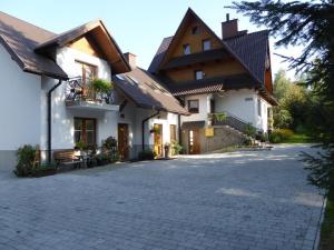 科尼基Pokoje i apartamenty pod Jaworzyną w Koninkach的一座带砖瓦车道的大型白色房屋