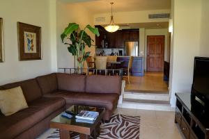 卡波圣卢卡斯Dunas 102的一间带棕色沙发的客厅和一间厨房
