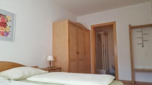 布列瑟农Kienasthof的一间卧室配有一张床和一个木制橱柜