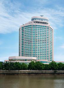 广州广州凯旋华美达大酒店的一座大型建筑,在河边有很多窗户