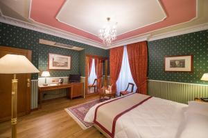 佛罗伦萨斯托洛兹皇宫酒店的一间卧室配有一张床和一张书桌