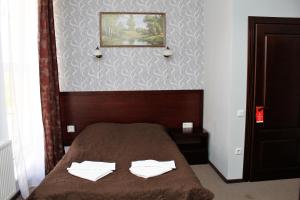 切尔诺夫策City Club European的一间卧室配有一张带两条白色毛巾的床