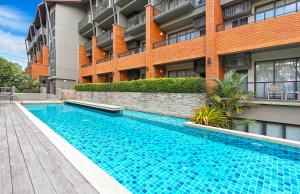 尖竹汶Rimnaam Klangchan Hotel - SHA Plus的大楼前的游泳池