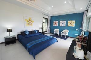 北冲班赢考度假村的一间卧室设有蓝色的床和蓝色的墙壁