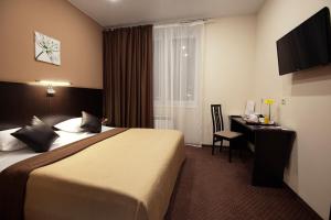 卡马河畔切尔尼Hotel Krokus的配有一张床和一张书桌的酒店客房