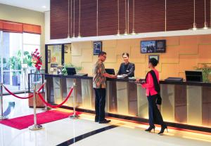 泗水泗水美居酒店的三人站在大厅的柜台
