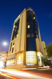 多哈Kingsgate Hotel Doha by Millennium Hotels的前面有一条街道的高楼