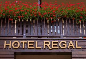 锡纳亚Hotel Regal的 ⁇ 上红色鲜花的酒店标志