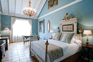 塔扎克蒂Hotel Hacienda de Abajo-Adults Only-Lujo的一间卧室配有一张带蓝色墙壁和吊灯的床。